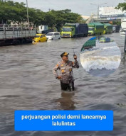DI TENGAH BANJIR KUDUS, POLISI TETAP BERDIRI MENGATUR LALU LINTAS Dedikasi Petugas Tuai Apresiasi Warga yang Melintas